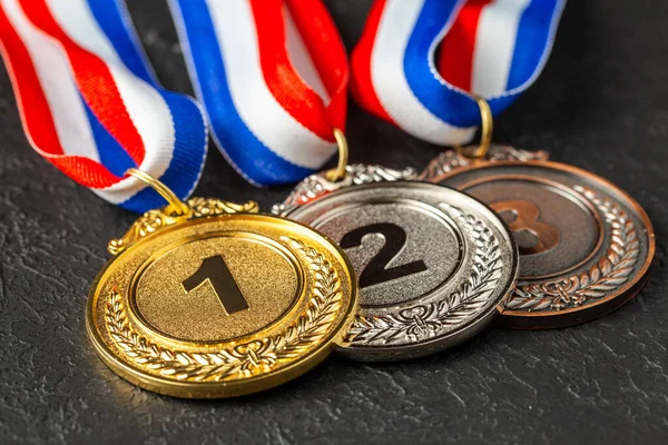 Medalha de ouro, prata e bronze com fitas. Prêmio pelo primeiro, segundo e terceiro lugar na competição. Prémio ao campeão. Fundo preto — Fotografia de Stock