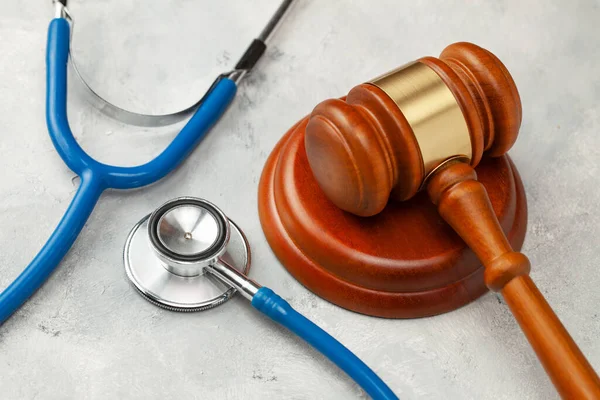 Sędzia młotek i stetoskop. Prawo w medycynie, wyrok w sprawie zaniedbań medycznych — Zdjęcie stockowe