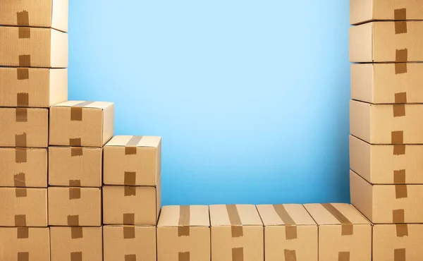 Caixas de papelão quadro para entrega ou em movimento. Pilha de caixas e fundo azul — Fotografia de Stock
