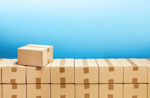 Caixas de papelão para entrega ou movimentação. Pilha de caixas e fundo azul — Fotografia de Stock