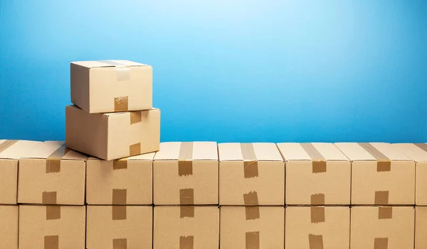 Cardboard boxes for delivery or moving. Stack of boxes and blue background — Stock Photo, Image