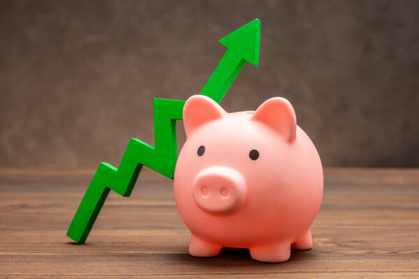 Green up arrow and piggy bank on brown.