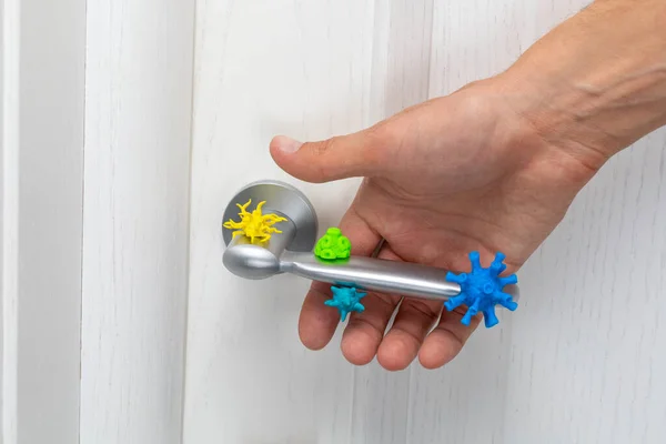 Coronavirus och andra bakterier på dörrhandtaget. En man med handen tar tag i ett infekterat handtag — Stockfoto