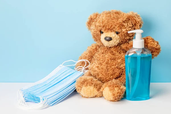 Protecting children from the virus. Teddy bear with sanitizer and medical masks — 图库照片