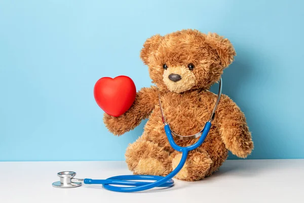 Çocuk doktoru ya da aile doktoru. Steteskoplu oyuncak ayı kırmızı kalp taşıyor.
