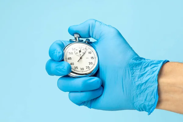 Doctor in glove holds stopwatch in his hand. Fast medical assistance and consultation concept — Stock Photo, Image