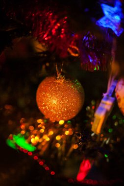 Geleneksel kırmızı ve altın rengi oyuncaklarla süslenmiş Noel ağacı, parlak Noel çelengi