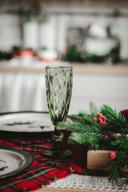 Masada kırmızı dekorlu yeşil cam, İskoç tarzı yeni yıl masası.