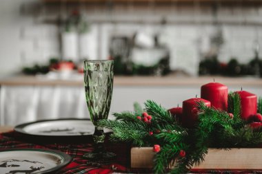 Masada kırmızı dekorlu yeşil cam, İskoç tarzı yeni yıl masası.