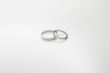 Beyaz arka planda beyaz metalden yapılmış klasik alyanslar.