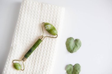 Yeşil yeşim yüz masajı silindiri beyaz havlu, yüz spa, ev bakımı