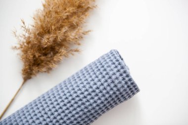 yumuşak voluminous lüks mavi havlu beyaz arka planda kuru pampa otları ile