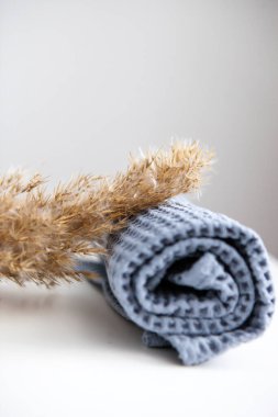 yumuşak voluminous lüks mavi havlu beyaz arka planda kuru pampa otları ile