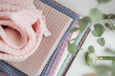 Açık renkli fotoğraf, açık arkaplanda bir yığın havlu.