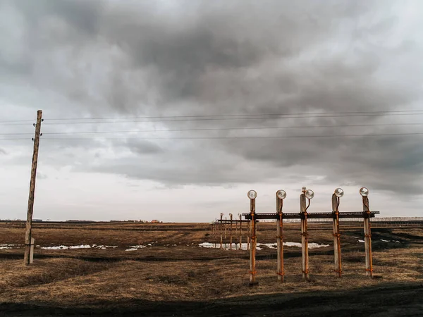 landing strip lights among spring fields on a cloudy day