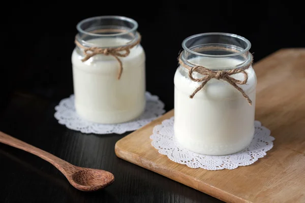 Yogur natural en un frasco sobre el fondo oscuro —  Fotos de Stock