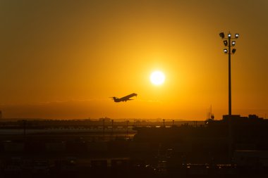 Havaalanı günbatımında bir düzlemde silüeti