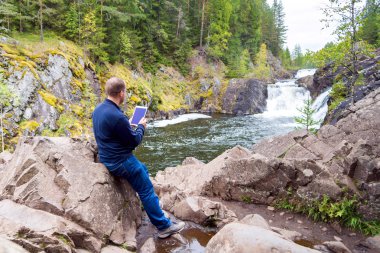 Dışarıda tablet bilgisayar kullanan bir adam.