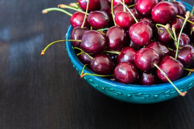 koyu arka plan üzerinde yeşil seramik kase kırmızı kiraz