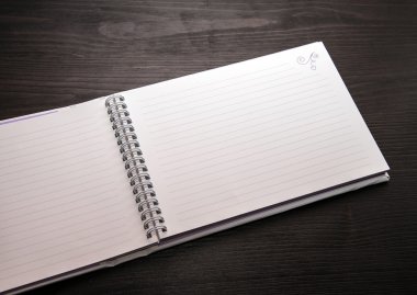 koyu ahşap arka plan üstünde spiral defter