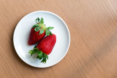 iki taze çilek beyaz tabakta görüntülemek yukarıdan