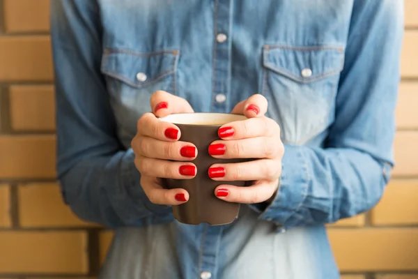 Mains féminines tenant une tasse de café chaud — Photo