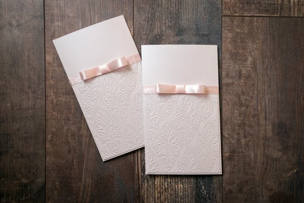 handmade card with embossed details and pink bow on wood background