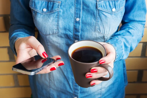 Femme avec tasse de café en utilisant le téléphone — Photo