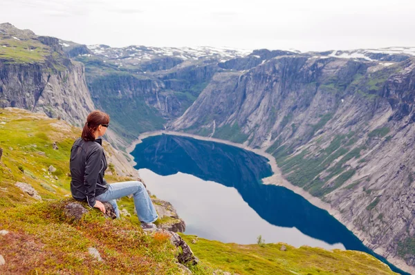 Woman looking at the lake in the mountains, Norway. Path to Trolltunga or Troll tongue — Stock Photo, Image