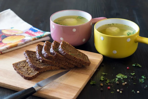 Soupe aux boulettes de viande dans un bol coloré avec des tranches de pain de grain — Photo