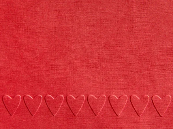Background of red paper with embossed hearts — Stock Photo, Image