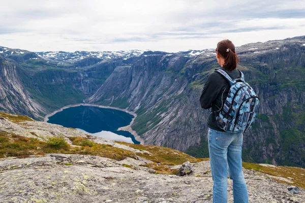 Woman looking at the lake in the mountains, Norway. Path to Trolltunga or Troll tongue — Stock Photo, Image