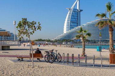 Uçurtma plajında bisiklet dostu sahil gezintisi, park edilmiş bisikletleri, yürüyüş yolları, sahil girişi. Bisiklet sürmek, gezmek ve Dubai yaşam tarzının tadını çıkarmak için mükemmel bir yer. 24 Ocak 2025 Dubai, BAE