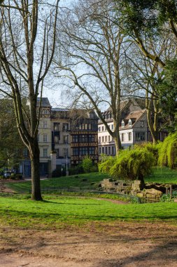 Fransa 'nın Rouen şehrinde baharın yeşilliği Saint Ouen Manastırı Kilisesi' nin yanındaki halk bahçesinde görülür, çimenleri ve yapraklı ağaçları kaplayan evler, gün ışığında yeşillik, rahat bir hava hissi verir.