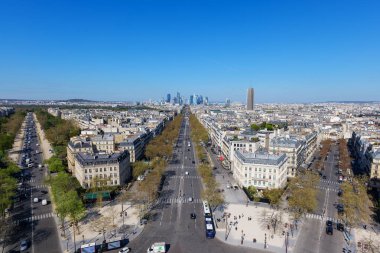 Paris, Fransa - 3 Nisan 2025. Panoramik Paris manzarası, ağaç kaplı cadde, klasik çatılar ve modern La Defense silueti, tarihi cazibenin güçlü zıtlığı ve çağdaş şehir manzarası.