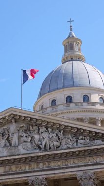 Paris 'teki tarihi Pantheon anıtı kubbenin üzerinde ulusal bayrak sallıyor. Güçlü mimari çizgiler ve miras sembolizmi eğitim, hükümet ve kültürel kimlik temalarına uygun