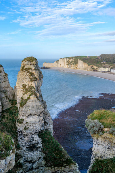 Panoramic aerial style view of Etretat bay with famous chalk cliffs and coastal town along Normandy shoreline. Scenic travel landscape showing iconic France coastline and tourism destination