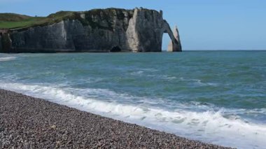 Fransa, Normandiya 'daki Etretat kayalık plajından bahar günü manzarası. Güneşli beyaz tebeşir kayalıkları denizin üzerinde yükselir, dramatik kıyı manzarası, ikonik doğal manzara, parlak ve manzaralı bahar atmosferi