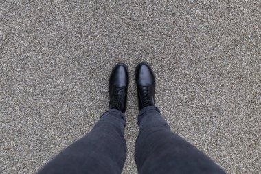 Asfalt beton zeminde duran siyah ayakkabılar. Dışarıda yürüyen ayaklı ayakkabılar. Genç Selphie hipster