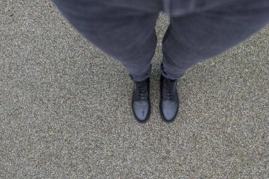 Asfalt beton zeminde duran siyah ayakkabılar. Dışarıda yürüyen ayaklı ayakkabılar. Genç Selphie hipster