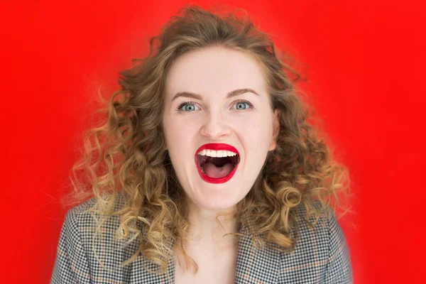Young blonde woman with green eyes laughing over red background. Close up portrait of student curly girl. Expressive facial emotions — Stock Photo, Image