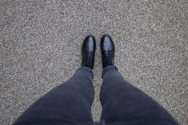 Чорне взуття стоїть на асфальтобетонній підлозі. Ноги взуття ходять на відкритому повітрі. Молодіжний Селфі Сучасний хіпстер — стокове фото