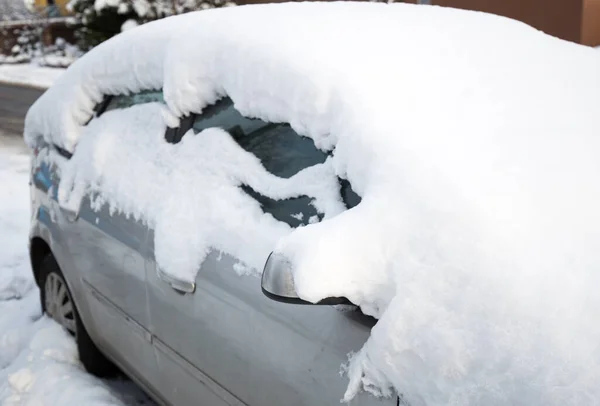 Zamarznięty samochód pokryty śniegiem w zimowy dzień. Pejzaż miejski, zaparkowany samochód — Zdjęcie stockowe