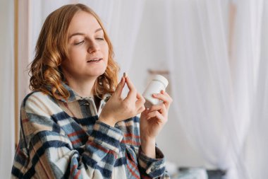 Sarışın kadının beyaz yuvarlak hapları ağzına koyduğu görüntüyü kapat. Hasta kadın ilaç, antidepresan, ağrı kesici ya da antibiyotik alıyor..