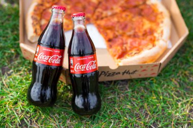 Cracow, Polonya, 12 Nisan 2021 - Pizza Hut kutulu klasik Coca-Cola şişeleri. Paket servis kavramı