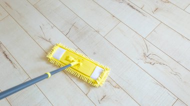 Mikrofiber sarı paspas beyaz ahşap zemin zemininde izole edilmiş, yakın plan, kapalı alan.