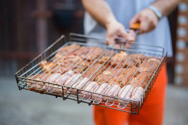 Un homme tenant un gril avec de la viande. Reste à la campagne dehors. Barbeque Grill Street Food. Cuisine barbecue d'été, pique-nique drôle. — Photo