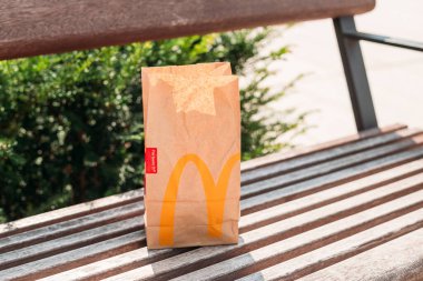 Cracow, Polonya, 12 Ağustos 2021 - Fast food restoranı McDonalds 'dan alınan yiyecek poşetleri, çevre kirliliği. Kahverengi kese kağıdı ve hamburger.