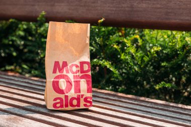 Cracow, Polonya, 12 Ağustos 2021 - Fast food restoranı McDonalds 'dan alınan yiyecek poşetleri, çevre kirliliği. Kahverengi kese kağıdı ve hamburger.