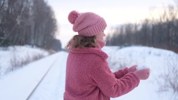Eine Junge Frau Rosafarbenen Kunstpelzmantel Pustet Winter Schnee Von Den — Stockvideo